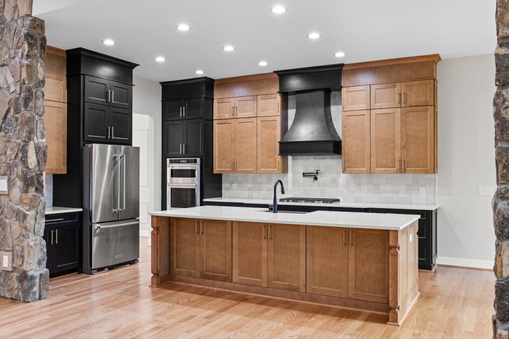 Spacious modern kitchen with wooden cabinetry and stone accents, featuring high-end appliances.