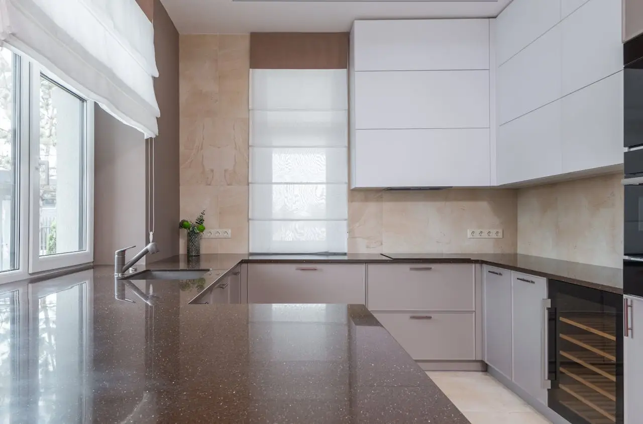 Stylish minimalist kitchen interior with glossy countertops and modern cabinetry.